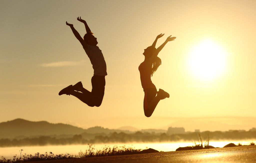 fit couple jumping in the air