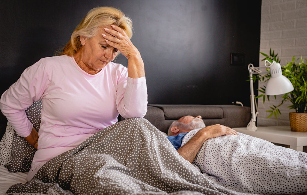 older woman in bed with lower back pain