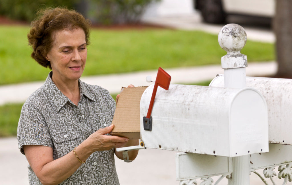 woman retrieving package from mailbox