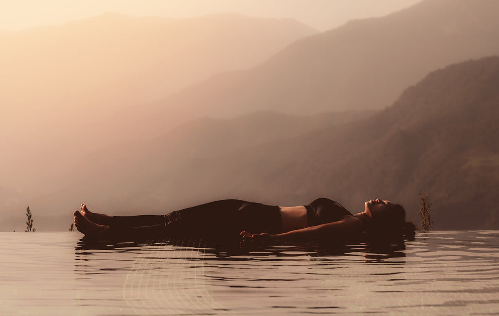 woman in yoga corpse pose floating on water