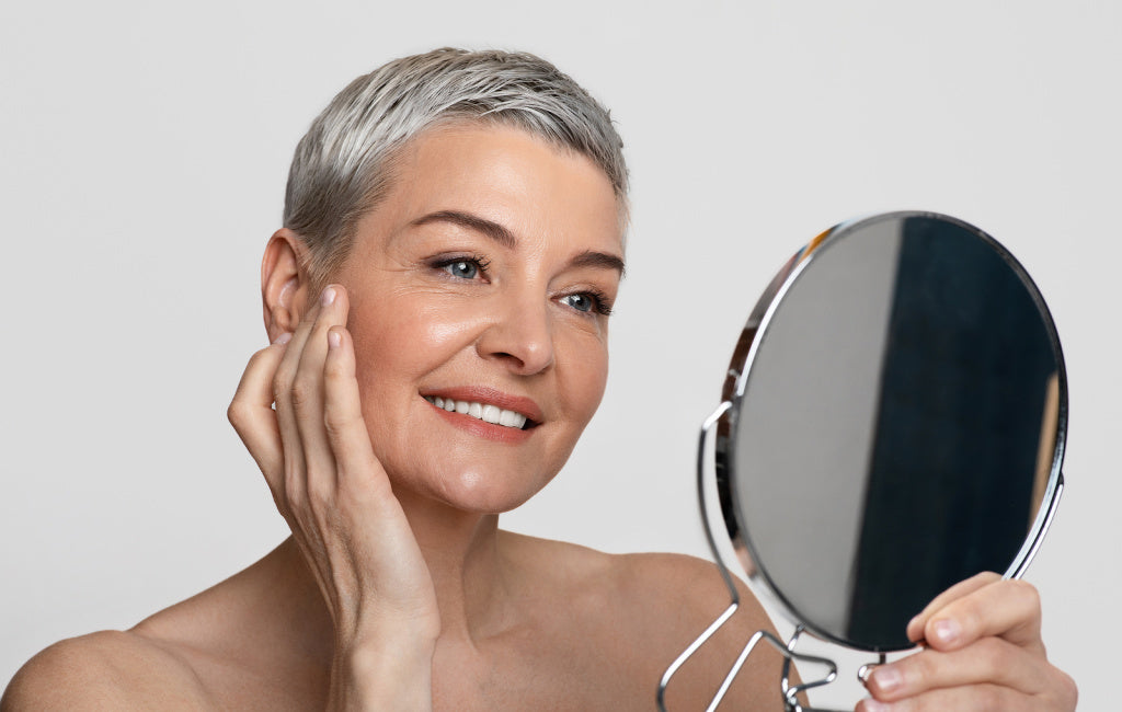 older woman looking at face in mirror