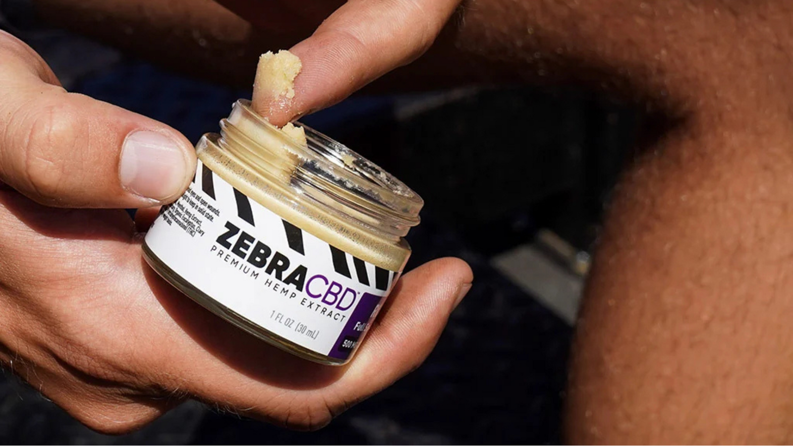  Man using CBD cream for knee pain after a workout